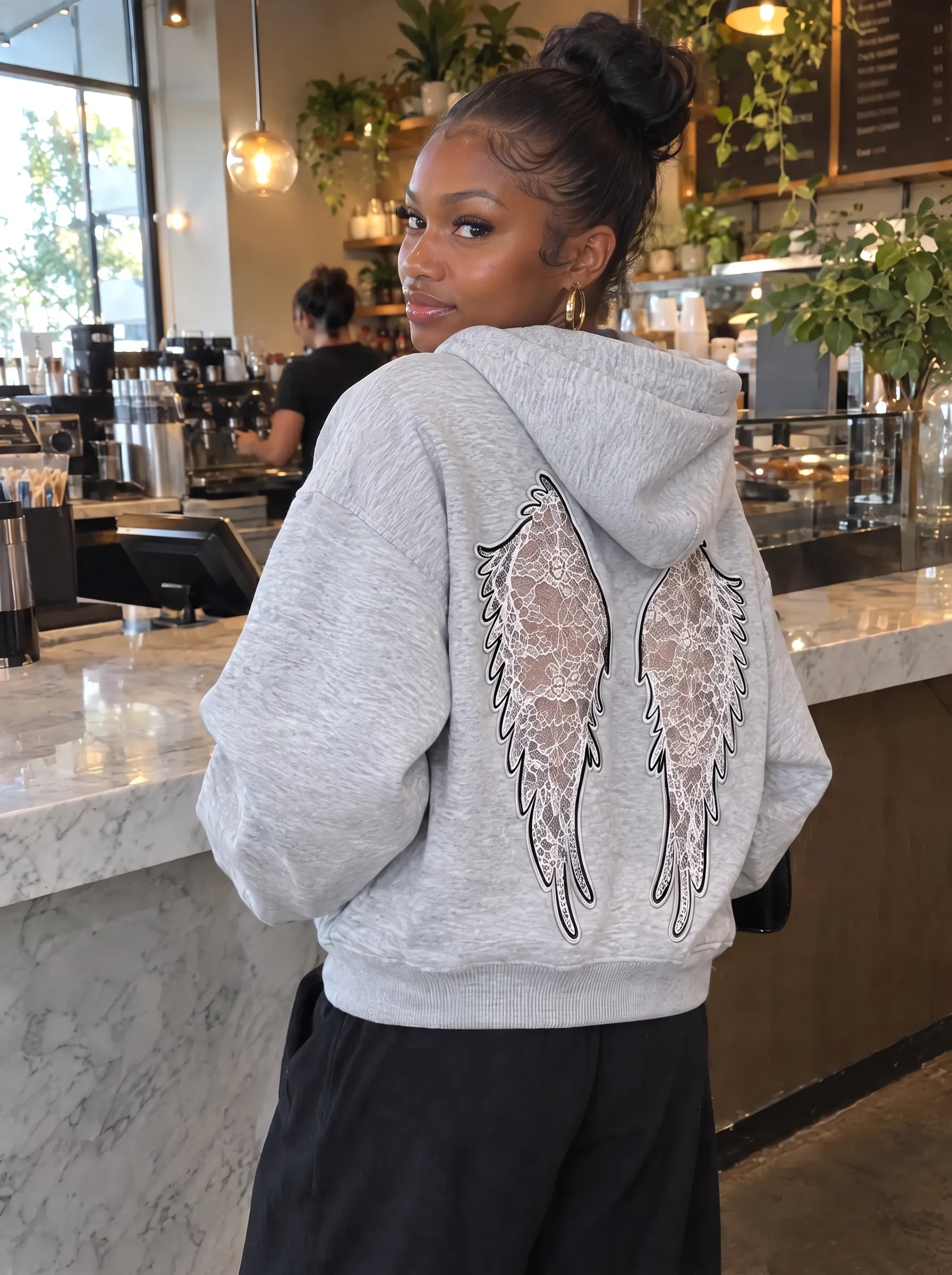 Heather Grey Laced Wing Hoodie with a direct-to-camera gaze.