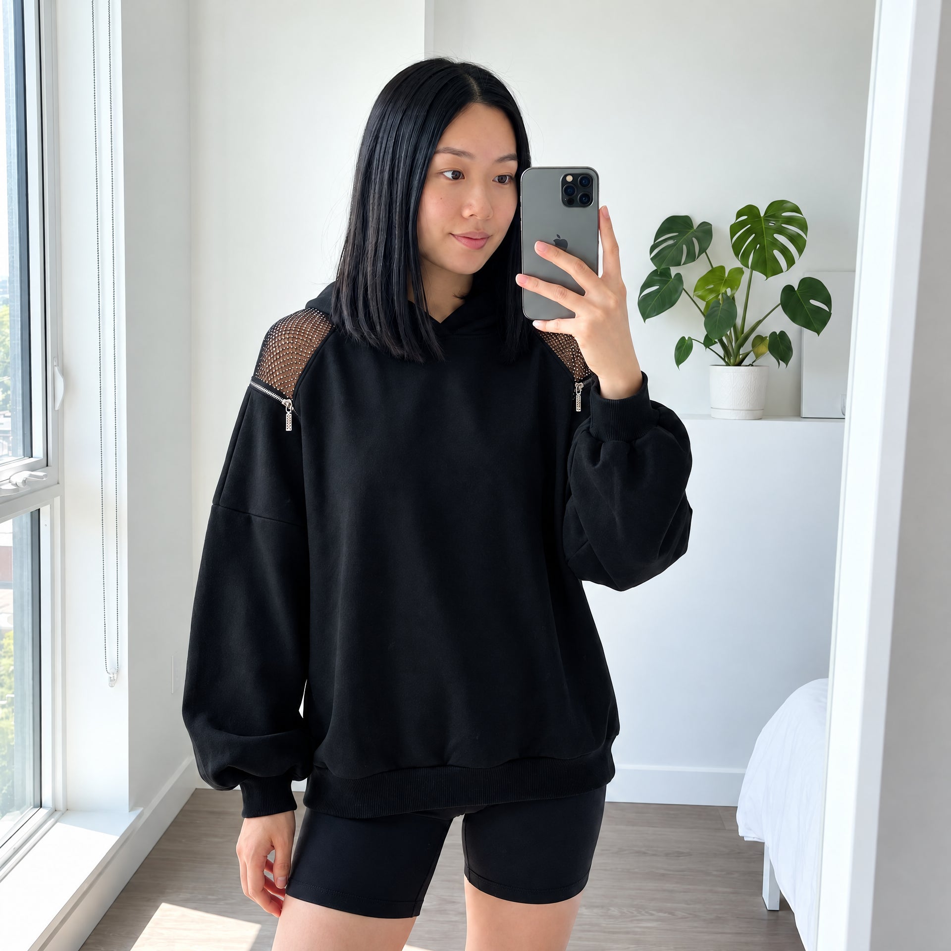 Black Backless Hoodie styled in a bright mirror photo.